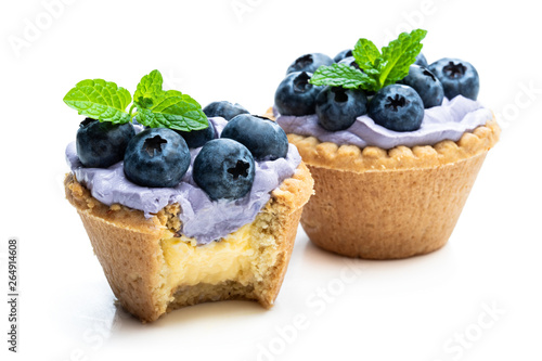 Mini tarts with blue cream and fresh blueberries isolated on white background