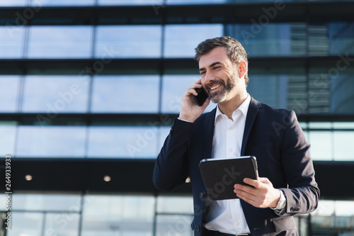 Hombre de negocios hablando por teléfono sonriente