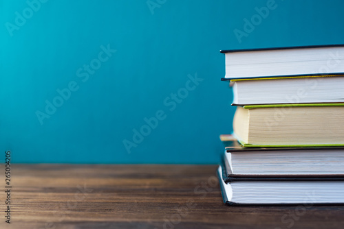 Books on table in front of chalk board. Back to school concept with copy space for text