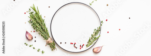Empty plate with greens herbs and spices around