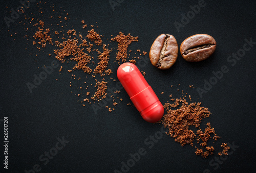 red pill and coffee beans on a black background, the concept of drugs containing caffeine
