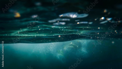 View from under the water on dirty water with floating debris and garbage