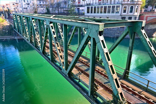 Old metal railway bridge in the city of Ivera, straddling the Dora Baltea river, Piedmont, Italy