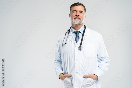 Cheerful mature doctor posing and smiling at camera, healthcare and medicine.