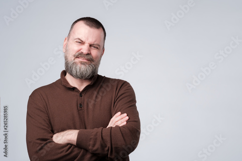 Angry, pissed off mature man with arms crossed folded.