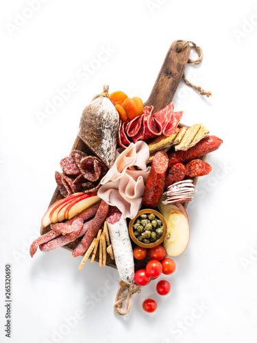 Cold meat plate, charcuterie on white background with copy space. Traditional Spanish tapas selection - chorizo, salchichon, jamon serrano, lomo, salami.