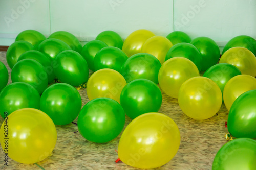 Balloons of two colors green and yellow lie on the floor.
