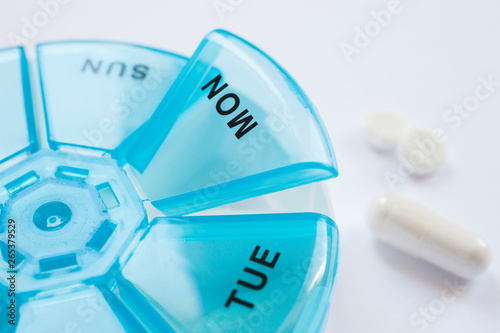 Tabletten liegen mit einer Tablettendose auf einem Tisch