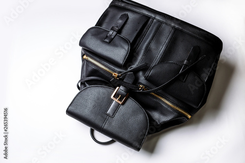 black leather backpack with golden zipper pockets on a white background