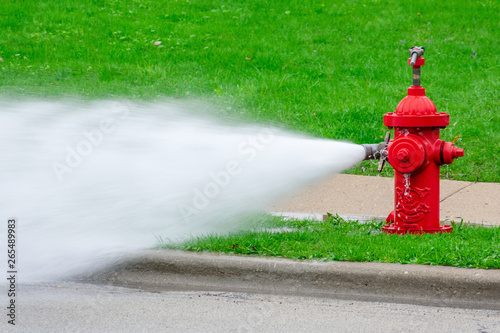 Closeup of red fire hydrant with high pressure spray