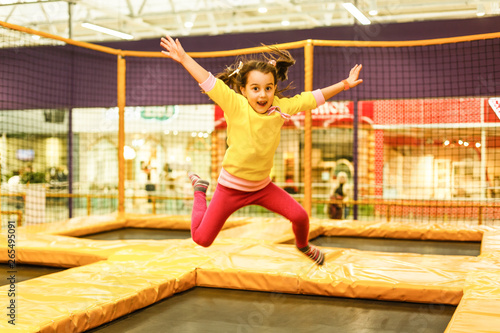 happy childhood of a modern child in the city - girl jumping in the trampoline park