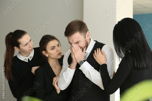 Relatives calming young widower at funeral