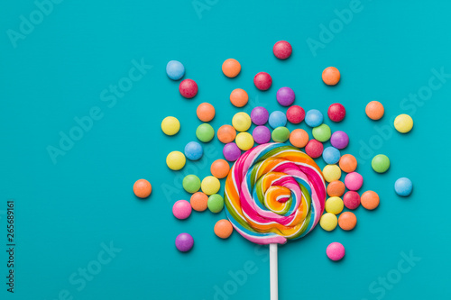 Sweet lollipop and colorful chocolate candy pills.