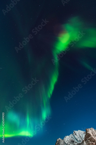 Green aurora borealis northern lights on dark blue sky