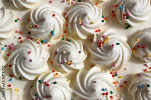 Festive curls for white cream cake with multicolored sprinkles