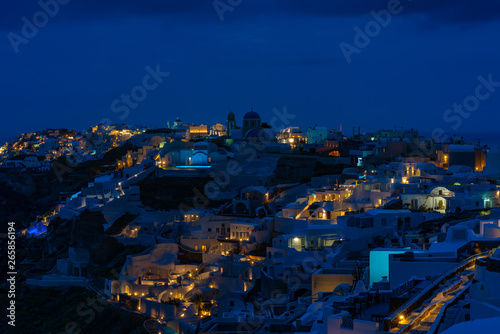 Santorini landscape with night view of whitewashed houses in Oia, Greece