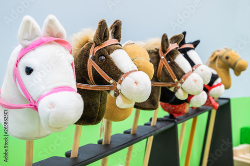 Row of multicolored hobbyhorses - children toys.