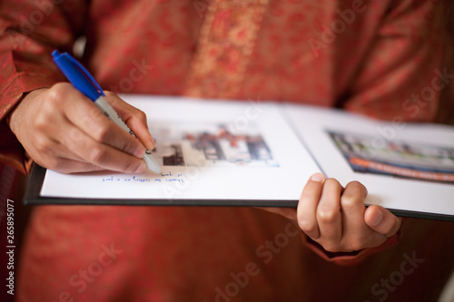 Person signing guestbook at Indian wedding