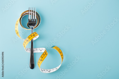 Fork with measuring tape around, diet background