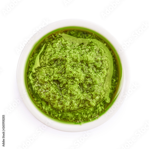 Bowl of tasty pesto sauce isolated on white, top view