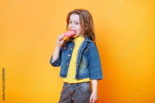 Baby girl eating ice cream on yellow background with free text copy space