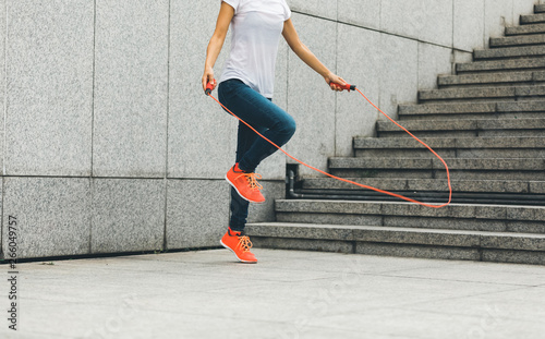 young fitness woman jumping rope outdoor