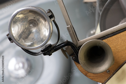 The headlight with horn on the old car. Veteran car with the classical klaxon and reflector, close up.