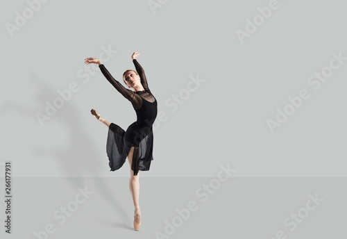Female ballet dancer dancer over gray background.