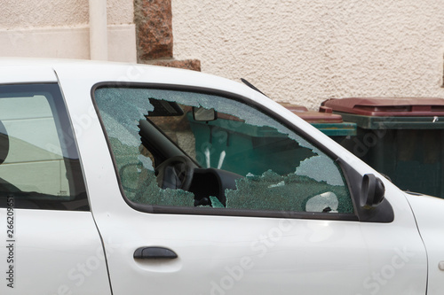 Broken window of a car parked in a street
