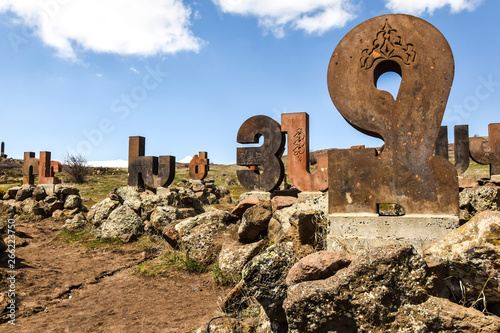 monument statue alphabet letters made of stone standing on rocks on the nature of abstraction