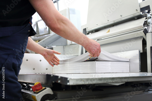 Paper trimming on a guillotine. Printing house. Cutter for cutting paper.