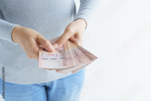 Asian woman hand counting money on white background. Money baht of thailand in her hand.