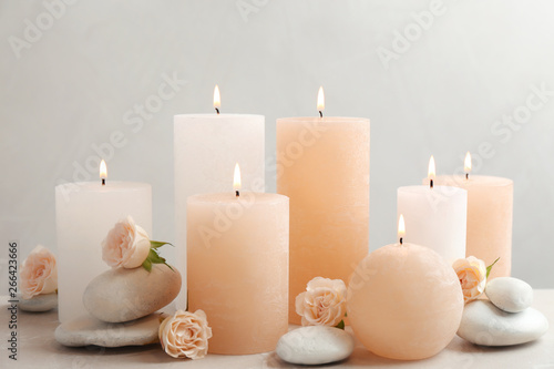 Beautiful composition with candles on table against grey background