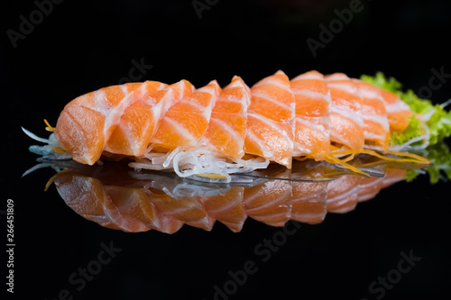 Łososiowy Sashimi na Czarnym Ceramicznym talerzu, czarny tło.