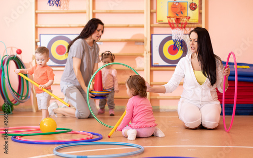 Kids toddlers play with adults in kindergarten gym