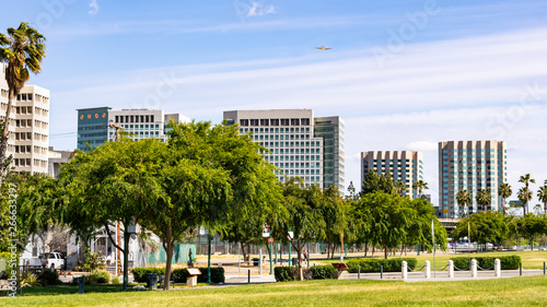 San Jose's downtown skyline as seen from the shoreline of Guadalupe River Park on a sunny spring day; Silicon Valley, California