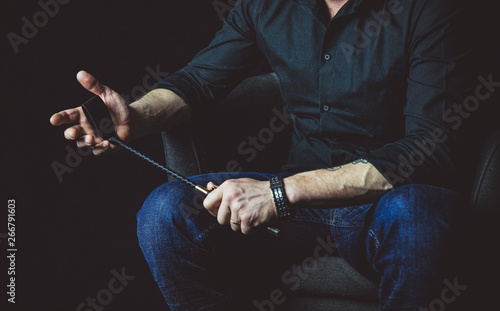 Strict man with bat. BDSM concept.