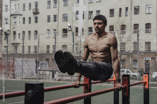 Athlete practicing calisthenics with smartwatch on his wrist.