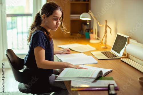 Teenage girl doing homework in her room