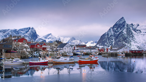 Beautiful winter landscape of harbor with fishing boat and traditional Norwegian rorbus