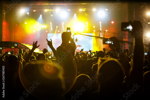 Many people with smartphones record outdoor music festival.