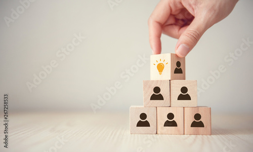 Leader with idea and innovation, Woman hand flips cube with icon light bulb and human symbol.