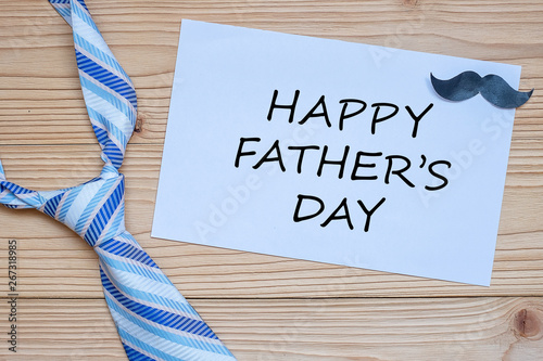 Happy Father's Day with blue neckties and mustache on wooden background. International Men's Day concepts