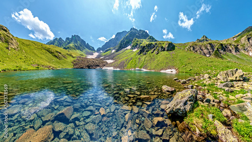 Turquoise water in lake Kalalish with peaks in background, Svaneti mountains, Georgia, Asia