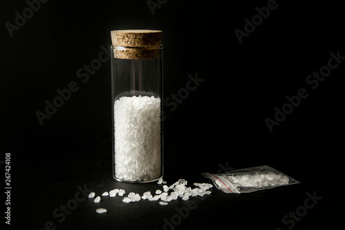 Conceptual image of "bath salts" synthetic cathinones drugs narcotics concept. White crystal powder on black background( set up), resemble to bathroom bath salt.