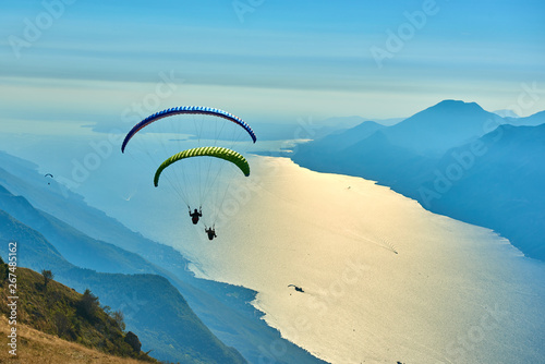 Paraglider flying over the Garda Lake,Panorama of the gorgeous Garda lake surrounded by mountains, Malcesine,Italy