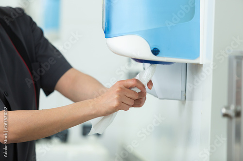 hands usings a tissue dispenser