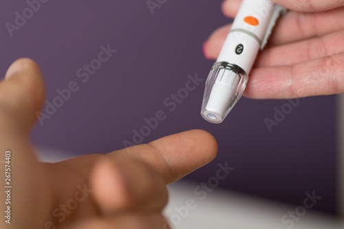 Man doing blood test with lancet hand prick