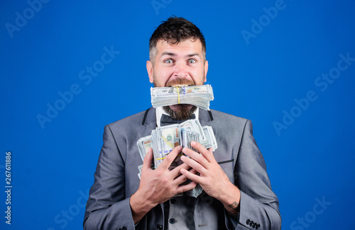 Cash transaction business. Easy cash loan. Man formal suit hold many dollar banknotes blue background. Businessman got cash money. Take my money. Gain real money. Richness and wellbeing concept