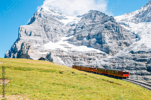 Jungfrau Eigergletscher snowy rocky mountain and red train in Switzerland